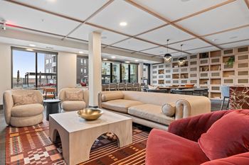club room with couches and chairs and a table at The Hallon Luxury Apartments in Hopkins MN